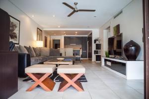 a living room with a couch and a table at 131 Temple Luxury Swimout Apt in Port Douglas