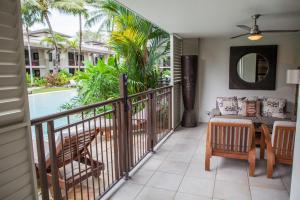 a balcony with a table and chairs and a couch at 131 Temple Luxury Swimout Apt in Port Douglas