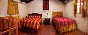 1 dormitorio con 2 camas en una habitación en Kallpa Wasi, en Cotacachi