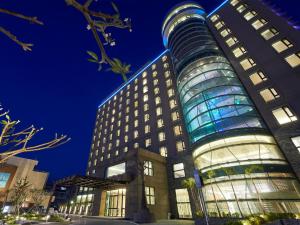 un palazzo alto con facciata in vetro di notte di Grand Bay Resort Hotel a Città Vecchia di Hengchun
