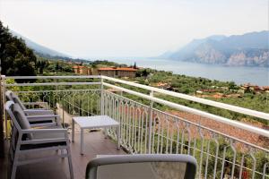 a balcony with chairs and a view of the water at Villa Arianna Panoramic Apartments in Malcesine