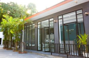 a building with large glass windows and palm trees at iRest Ao Nang Seafront - SHA Plus in Ao Nang Beach