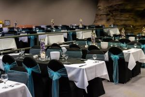 a banquet hall with tables and chairs with bows at Capricorn Motel & Conference Centre in Rockhampton +32 photos