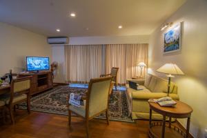 a living room with a couch and a television at Sakura Residence & Hotel in Yangon