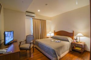 a hotel room with a bed and a desk and a television at Sakura Residence & Hotel in Yangon +17 photos