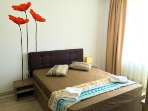 ein Schlafzimmer mit einem Bett mit zwei roten Blumen drauf in der Unterkunft Skyline Residence Summerland in Mamaia