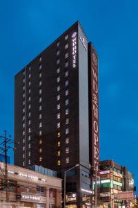 Un edificio alto y negro con un cartel. en WD Hotel, en Seúl
