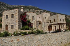 a stone building with flowers on a wall at Lithochtisto in Monemvasia +16 photos