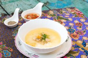 a bowl of soup on a plate on a table at Baan Nai Nakhon in Songkhla