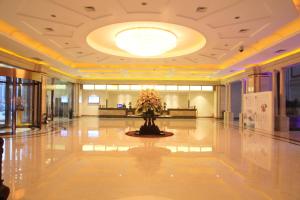 a lobby with a vase of flowers on the floor at Hui Fu Jinling Hotel in Gaoyou