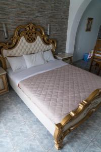 1 dormitorio con 1 cama grande con marco dorado en Orama Apartments, en Agia Anna de Naxos
