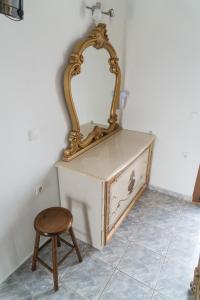 een spiegel op een dressoir met een kruk bij Orama Apartments in Agia Anna Naxos