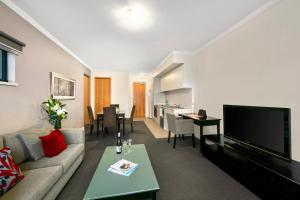 a living room filled with furniture and a tv at Quest on Rheola in Perth