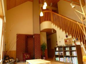 a room with a staircase and a book shelf with books at Forestlodge Subaru in Teshikaga