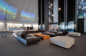 eine Lobby mit Sofas und Tischen in einem Gebäude in der Unterkunft BAH Barcelona Airport Hotel in El Prat de Llobregat