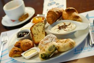 a plate of food with pastries and a cup of coffee at Kos Aktis Art Hotel in Kos