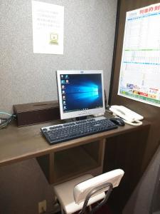 a desk with a computer monitor and a keyboard and mouse at Hirosaki Grand Hotel in Hirosaki