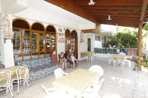 two people sitting on a bench on a patio at Vardar Pension in Selçuk
