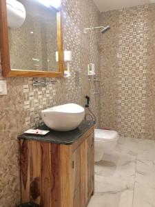 uma casa de banho com um lavatório, um WC e um espelho. em Hotel Khamsum em Paro