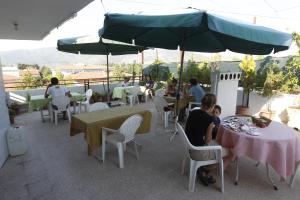 a group of people sitting at tables on a patio at Vardar Pension in Selçuk