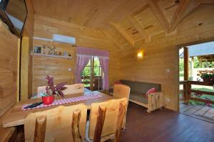 a wooden cabin with a table and a couch at Apartments Zafran in Smoljanac