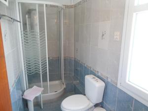 a bathroom with a shower and a toilet and a sink at Adonis Rooms in Skopelos Town