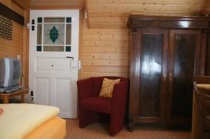 a bedroom with a bed and a red chair at Antik Apartments Spreewald/Vetschau in Vetschau