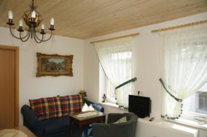 a living room with a couch and two windows at Antik Apartments Spreewald/Vetschau in Vetschau