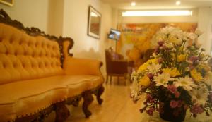 a living room with a couch and a vase of flowers at LEOS Hotel in Tomohon