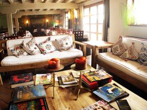 a living room with couches and a table with books at Kuko Hotel - Adults Only in Oronoz-Mugaire