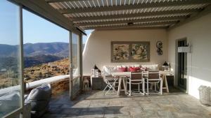 a dining room with a table and chairs on a balcony at Villa Baya in Ios Chora