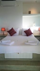 a large white bed with two towels on it at Villa Baya in Ios Chora