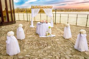 a wedding altar with four girls in white dresses and a table at Prestige Hotel in Belene
