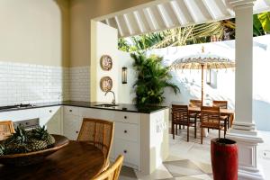 a kitchen with a table and chairs and an umbrella at Villa Antiga 2 in Seminyak