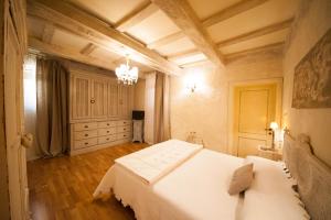 ボローニャにあるCestello 17 Guesthouseのベッドルーム(白いベッド1台、シャンデリア付)