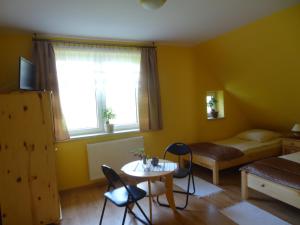 ein kleines Zimmer mit einem Bett, einem Tisch und Stühlen in der Unterkunft Apartamenty Gawędówka in Krościenko nad Dunajcem