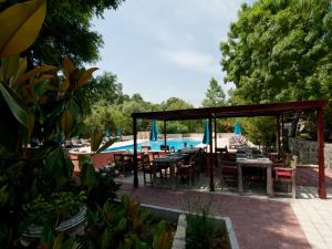 a patio with tables and chairs next to a pool at Fener Motel in Şile