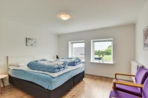 a bedroom with a bed and a purple chair at Bjerndrup Lejlighed in Bjerndrup