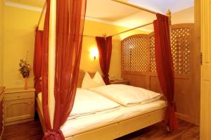 a bedroom with a four poster bed with red curtains at Die Bergresidenz in Zell am See