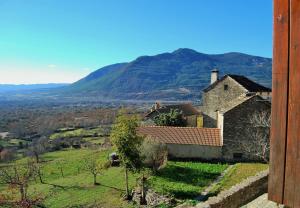 a house in a field with a mountain in the background at Casa Azon in Oliván