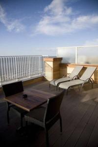einen Balkon mit einem Holztisch und Stühlen auf einem Schiff in der Unterkunft Hotel De Zeebries in Middelkerke