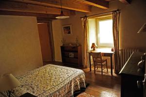 - une chambre avec un lit, une table et une fenêtre dans l'établissement Sabatou, le cottage Cévenol, à Florac Trois Riviere