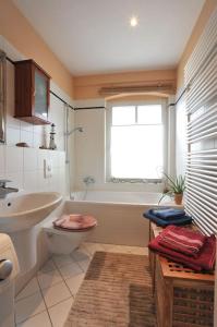 uma casa de banho com um lavatório, um WC e uma banheira em Wohnung mit Blick über Potsdam em Potsdam