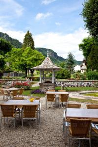 un groupe de tables et de chaises ainsi qu'un kiosque dans l'établissement Hotel Beauséjour, à Vic-sur-Cère