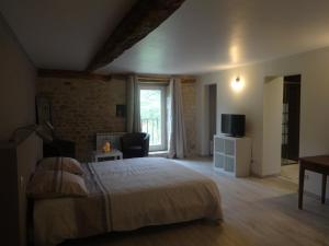 a bedroom with a bed with a television and a window at Lacoste B&B in Saint-Clair