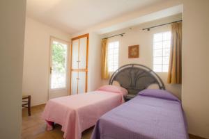 two beds in a bedroom with pink sheets at Al Pozzo Residence in Capoliveri +3 photos