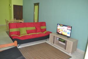sala de estar con sofá rojo y TV en Teknologi Kajang Homestay en Kajang