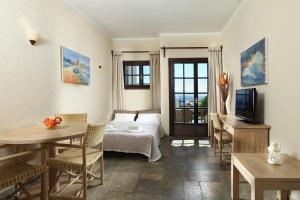 a living room with a bed and a table and chairs at Agnanti Hotel Apartments in Afissos