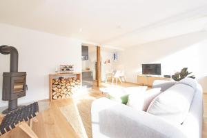 a living room with a white couch and a wood stove at Zehn in Bernkastel-Kues