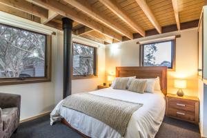a bedroom with a bed and two windows at Alta Villa in Dinner Plain